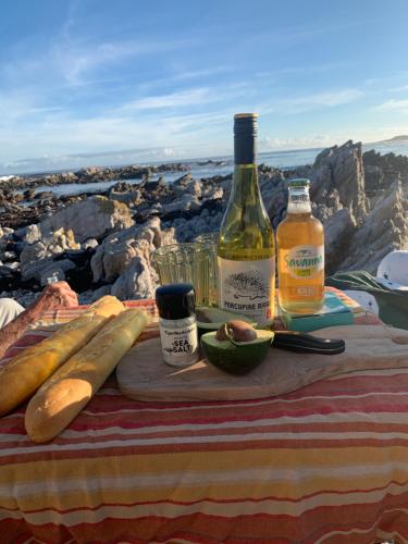a table with two bottles of wine and an avocado at The Missions House in Hermanus