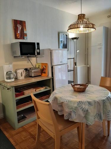 une salle à manger avec une table et un réfrigérateur dans l'établissement Studio Masol avec terrasse, à Amélie-les-Bains-Palalda