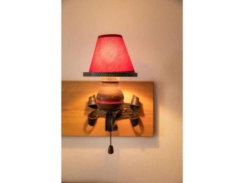 a lamp on a wall with a red lamp on it at Finkenhof in Schluchsee