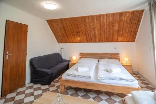 a bedroom with a bed and a black chair at Mikulov - Inn - hotel s vinným sklepem Venuše in Mikulov