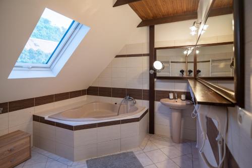 a attic bathroom with a tub and a sink at Mikulov - Inn - hotel s vinným sklepem Venuše in Mikulov
