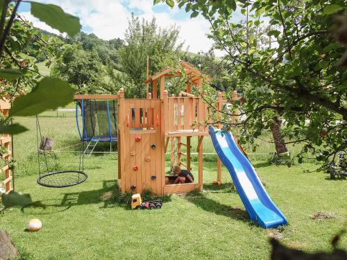 a wooden playset with a slide and a playground at Biobauernhof Stegerbauer in Maria Alm am Steinernen Meer