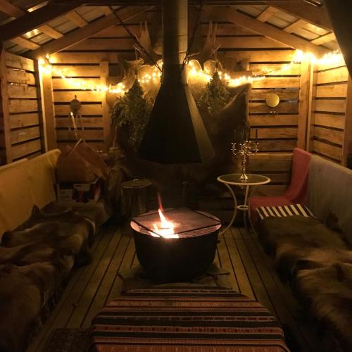 a room with a fireplace and couches and a fire pit at Villa Shaman in Rovaniemi