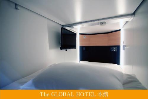 a bedroom with a bed and a window at The Global Hotel Tokyo in Tokyo
