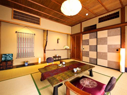 a dining room with a table and chairs in a room at Nanten-En in Kawachinagano