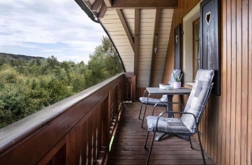 a porch with two chairs and a table on a house at Finkenhof in Schluchsee