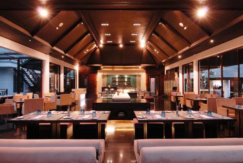 a restaurant with tables and chairs in a room at The Zign Hotel Premium Villa in North Pattaya