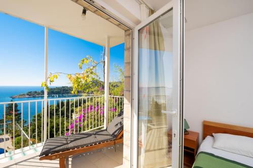 a bedroom with a balcony with a view of the ocean at Apartments Katica in Mlini