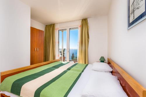 ein Schlafzimmer mit einem großen Bett mit Fenster in der Unterkunft Apartments Katica in Mlini