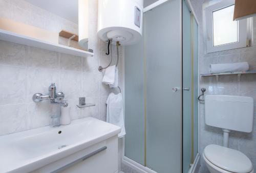 ein Badezimmer mit Toilette, Waschbecken und Dusche in der Unterkunft Apartments Katica in Mlini