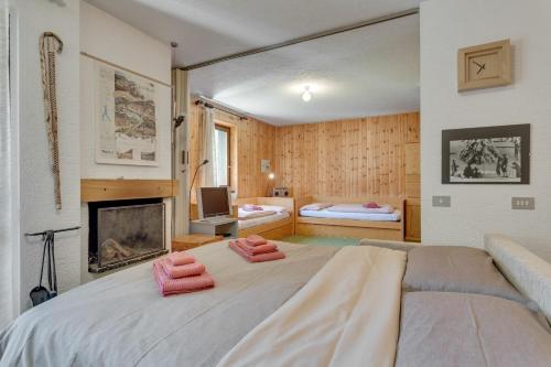 a bedroom with a large bed and a fireplace at Santa Caterina Isola Apartment in Santa Caterina Valfurva