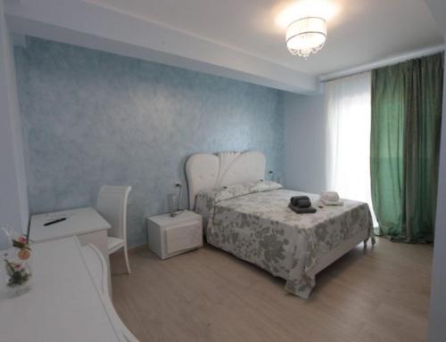 een slaapkamer met een bed, een tafel en een raam bij Albamaris Guest House in Botricello