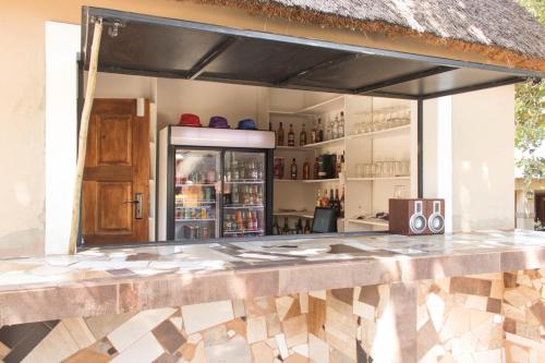 a kitchen with a counter with a refrigerator at Shingwedzi Hotel in Benoni