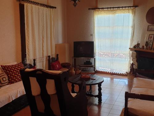 a living room with a couch and a table and a tv at House in a village of Taygetus in Sparta