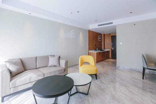 a living room with a couch and a table and a yellow chair at Hotel Casiana & Events Center Tagaytay in Tagaytay