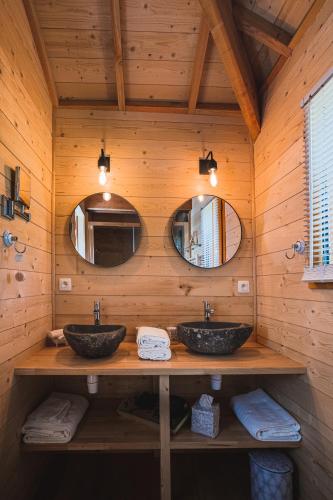 deux lavabos dans une salle de bain en bois avec deux miroirs dans l'établissement La Closerie de Sarlat Maison d hôtes de charme, à Sainte-Nathalène