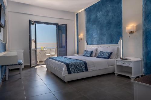 a bedroom with a large bed and a large window at Rivari Santorini Hotel in Kamari