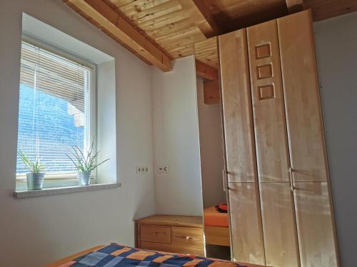 ein Schlafzimmer mit einem Kühlschrank und einem Fenster in der Unterkunft Ferienwohnung Christina in Ried im Zillertal