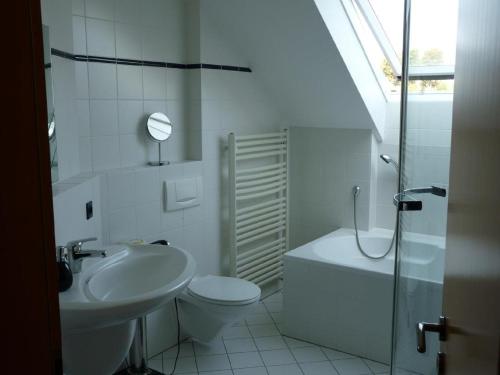 a white bathroom with a sink and a toilet at Ferienwohnung Natur pur in Bad Pyrmont