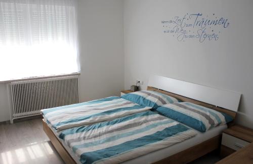 una camera con letto e lenzuola bianche e blu di Appartement Michelle a Neusiedl am See
