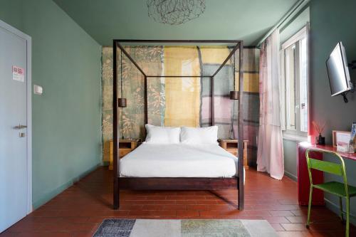 numa l Rodo Rooms & Apartments في فلورنسا: غرفة نوم بها سرير بأربعة أعمدة مع ملاءات بيضاء