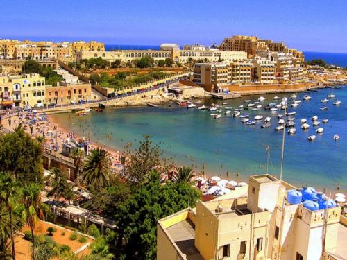 a view of a beach with boats in the water at Stunning Apartment in a Central Location with Views in Taʼ Xbiex