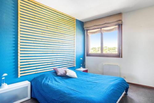 une chambre bleue avec un lit et une fenêtre dans l'établissement Residence des Coteaux du Preconil, à Sainte-Maxime