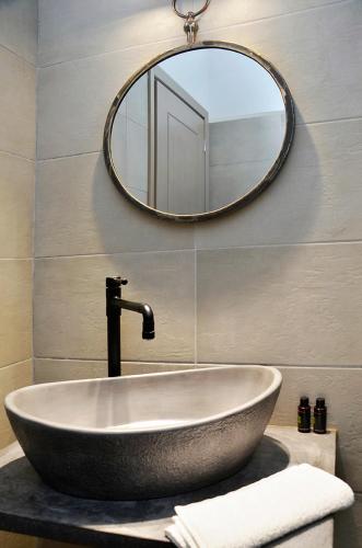 a bathroom with a bath tub and a mirror at Onar Studios in Koufonisia