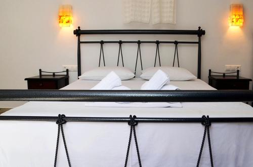 a bed with a black frame and two white pillows at Onar Studios in Koufonisia