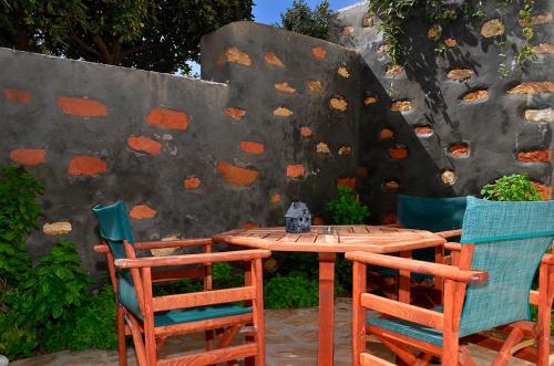 a wooden table with two chairs and a cat sitting on top at Onar Studios in Koufonisia