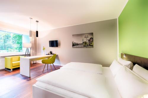 a bedroom with a white bed and a desk at Hotel Carolinenhof in Berlin