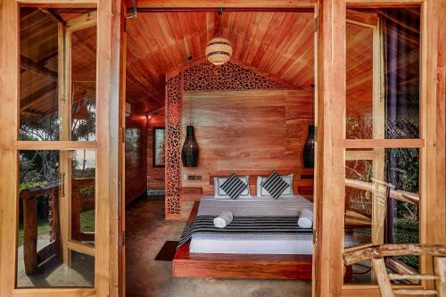 a bedroom with a bed in a wooden room at Sea View Clay House in Hiriketiya