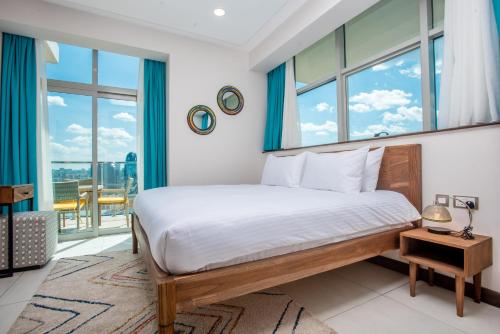 a bedroom with a bed and a large window at Skynest Residences by CityBlue, Nairobi Westlands in Nairobi