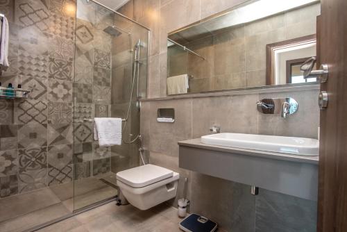 a bathroom with a toilet and a sink and a shower at Skynest Residences by CityBlue, Nairobi Westlands in Nairobi