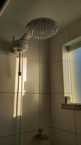 bagno con doccia, luce e specchio di Apart Resort Vila das Águas Veraneio a Estância