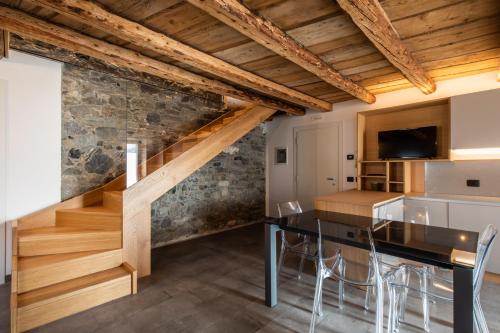 uma cozinha e sala de jantar com uma mesa e escadas em CASA VACANZE RANUNCOLO 6 em Sùtrio