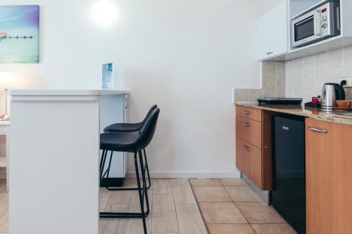 a kitchen with a black chair and a counter at Almog Haifa Israel Apartments מגדלי חוף הכרמל in Haifa