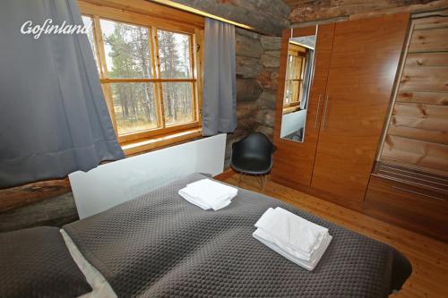 Kuukkeli Log Houses Aurora Resort tesisinde bir odada yatak veya yataklar