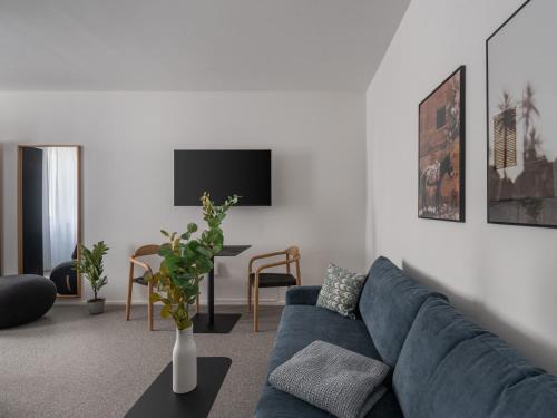 a living room with a blue couch and a tv at Limehome Linz Friedrichstraße in Linz