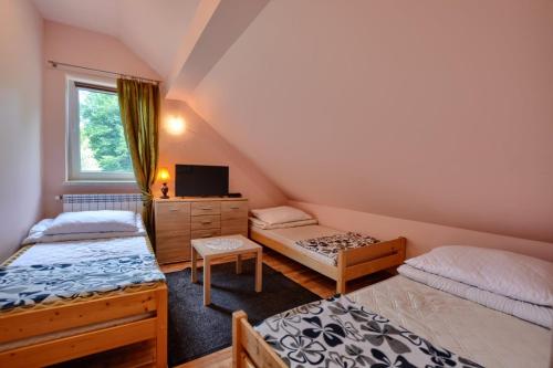 מיטה או מיטות בחדר ב-Ropuszy Dwór