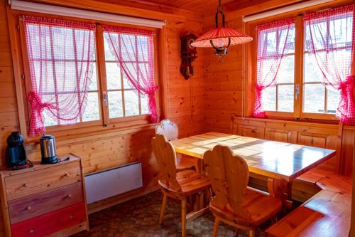 a wooden dining room with a wooden table and chairs at Chalet Valeria in Rosswald