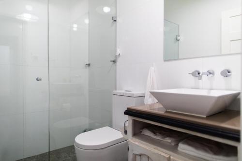 La salle de bains blanche est pourvue d'un lavabo et de toilettes. dans l'établissement WildLife Lodge Katoomba, à Katoomba