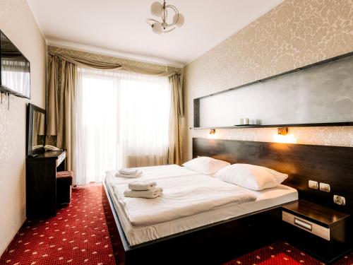 a bedroom with a large bed with a large headboard at Hotel Delicjusz in Trzebaw