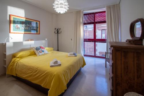 1 dormitorio con 1 cama con colcha amarilla en Apartamento Nuestra Andalucia - Cadiz Centro - parking, en Cádiz