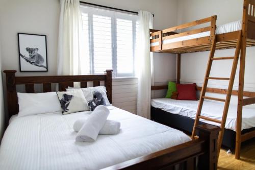 a bedroom with two bunk beds with white sheets at WildLife Lodge Katoomba in Katoomba