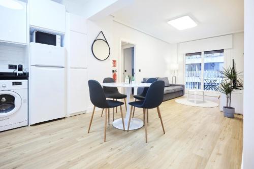 a kitchen and living room with a table and chairs at Izpizua Apartment in San Sebastián