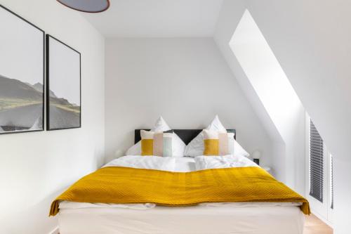 a bedroom with a bed with a yellow blanket at Apartments Passau Angerstraße in Passau
