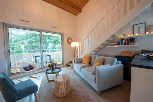 un salon avec un canapé et un escalier dans l'établissement Charmant appartement à deux pas de Saint Gilles Croix de Vie, à Saint-Gilles-Croix-de-Vie