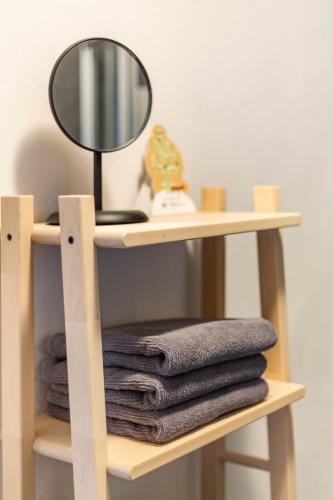 a shelf with a mirror and a pile of towels at Apartments Passau Angerstraße in Passau