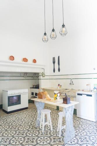 a kitchen with a table and two stools at Torre da Giesteira in São Brissos